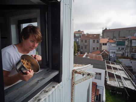 Woman throwing pasta out of the window, neighbor conflict conceptの写真素材