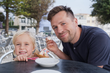 Girl Eating Ice Cream with Her Dad at a Cafeの写真素材