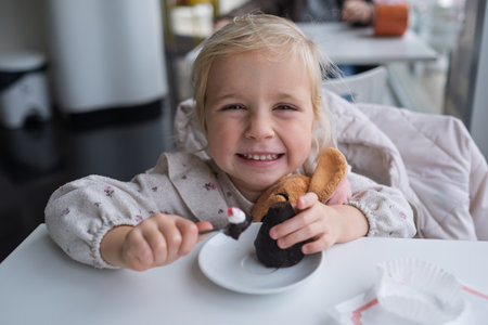 Girl eating chocolate cake in a cafeの写真素材