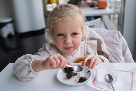 Girl eating chocolate cake in a cafeの写真素材