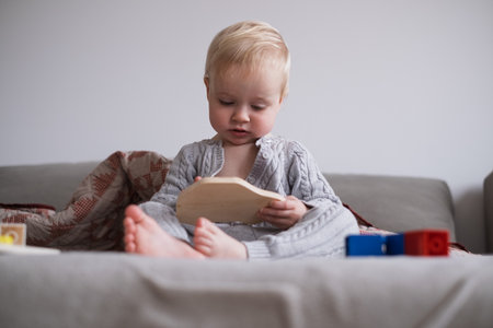 Little Toddler Girl Sitting on Bed Playing with Toys Independently