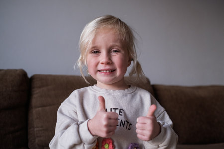 Little girl, 4 years old, showing thumbs upの写真素材