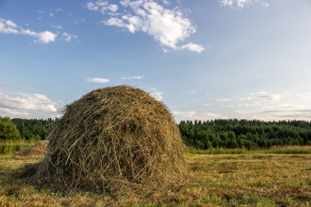 haystack in the rays of the evening sun on blue sky backgroundの写真素材