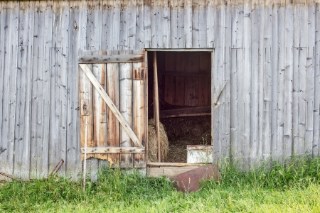 open door in an old barn with hayの写真素材