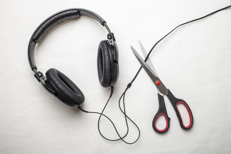 Scissors cut the wire from the headphones, and thus stop the very loud illegal pirated music on a...