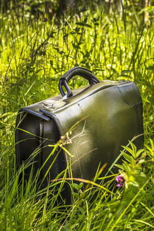 businessman came to rest in the village and left a bag in the grassの写真素材