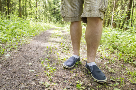 a man standing on the footpath after a long walk in the background forest and rays of the sun pass through the treesの写真素材