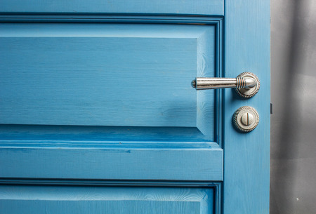 open wooden door painted in blue with a beautiful a metal handle and the castleの写真素材