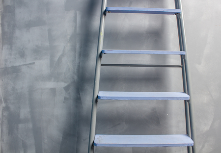 repair in an apartment by using a stepladder which stands leaning on painted gray wallの写真素材