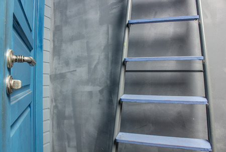 repair in an apartment by using a stepladder which costs around blue door leaning on the wallの写真素材
