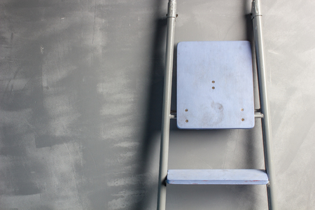 repair in an apartment by using a stepladder which stands leaning on painted gray wallの写真素材