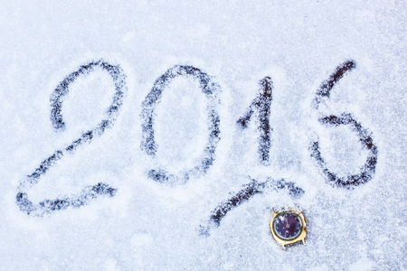 old watch lying in the snow in the 2016 New Year