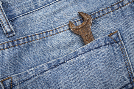 old, rusty wrench is in the back pocket of blue jeansの写真素材
