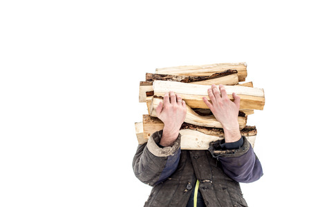 a man carries in his hand a great bunch of chopped firewood in the winter on a white backgroundの写真素材