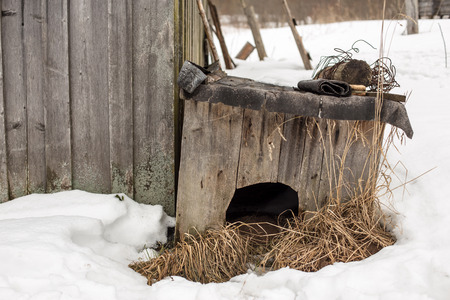 old wooden doghouse is about a barn in the village during the snowy winterの写真素材