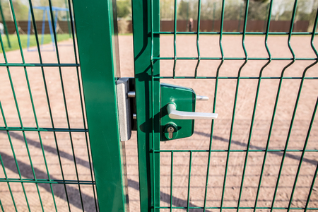entrance to the playground of fence and the wicket of the welded wire mesh green color with a metal...