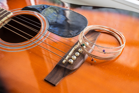 New guitar strings put on the acoustic guitar ready for replacementの写真素材