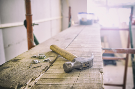 hammer and nails lying on the board in the room, in which there is a repairの写真素材