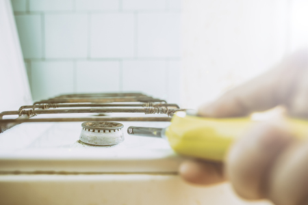 hand ignites the gas burner, using a lighter in the kitchen in the morningの写真素材