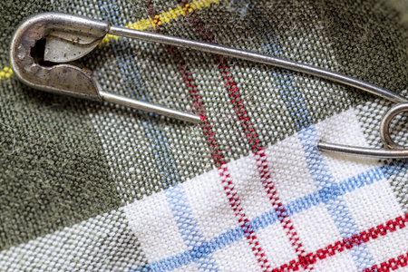 safety pin fastened to the colorful tartan shirtの写真素材
