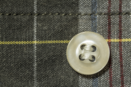 button fastened to the colorful tartan shirtの写真素材