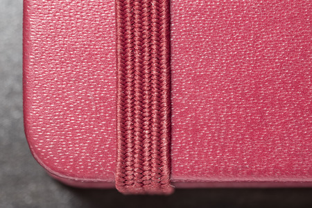 macro red notebook with bookmark, lying on a wooden tableの写真素材