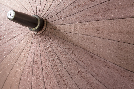 drops of water on a brown umbrella after rainの写真素材