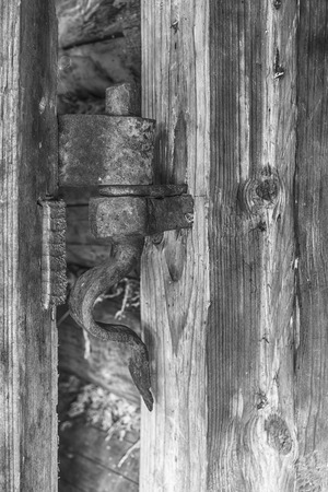 Vintage old rusty hinge on a wooden doorの写真素材