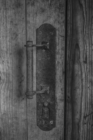 Old rusty handle on the wooden door of entranceの写真素材