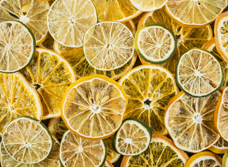 Dried colorful slices of lemon, the lime and orange background, close upの写真素材