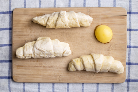 croissants and egg are like clouds and sun on a cutting boardの写真素材