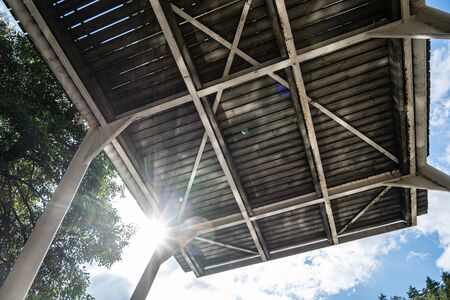 High diving board for training athletes, against the backdrop of the bright sun, blue sky and trees,...