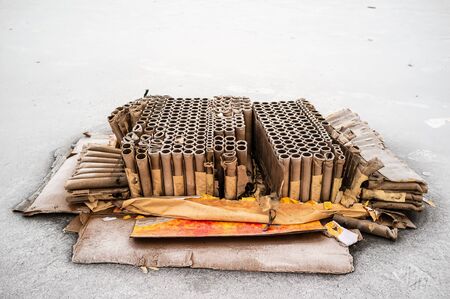 Used fireworks firecrackers lie on the asphalt covered with hoarfrost, on a winter day. Remaining garbage after the holiday.の写真素材
