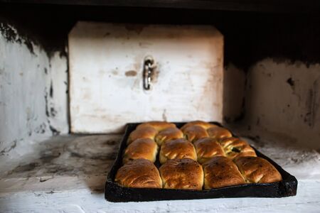 Cooked pies on a baking tray, which were baked and removed from the oven of an old, Russian oven, in a village house.の写真素材
