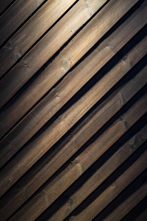 Dark wooden wall with a spot of light from above. Can be used as background.の写真素材