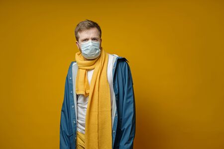 Perplexed man in a medical mask, looks anxiously at the camera. Copy space. Concept of the spread of the virus.の写真素材