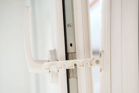 Open white PVC window with a fixing device for ventilation. Close-up.の写真素材