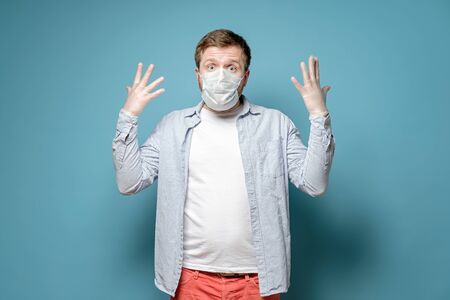 Man in a medical mask and latex gloves scared looks at the camera. Safety concept during dangerous virus and pandemic.の写真素材