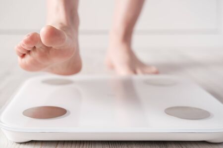 Female foot takes a step on smart scales that makes bioelectric impedance analysis, BIA, measurements of body fat.の写真素材