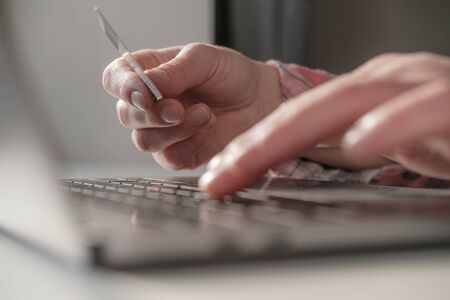 Female hands enter bank details of a credit card on a laptop to pay for online purchases. Concept of self-isolation due to a virus epidemic. Modern lifestyle. Close-up..の写真素材