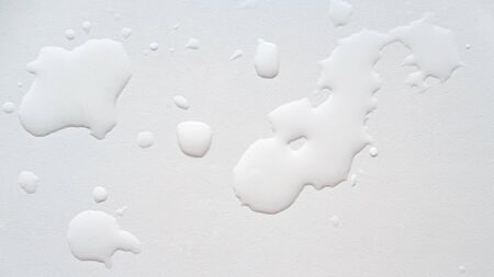 Spilled water on a white textured surface. Background. Top view.の写真素材