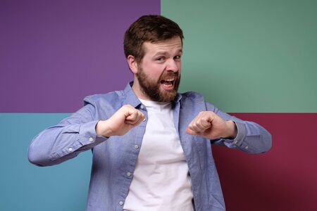 Caucasian man emotionally argues, proves something by pointing to himself with his thumbs.の写真素材