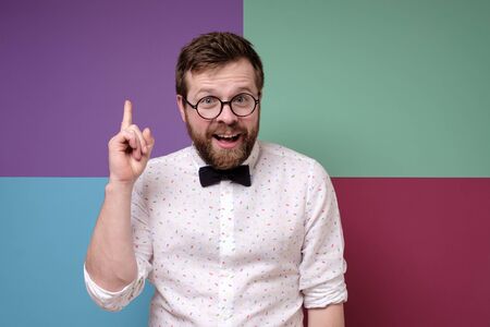 Funny Caucasian man raises his index finger up as a sign that he has a great idea.の写真素材