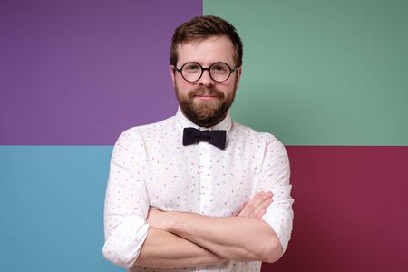 Cute, calm Caucasian bearded man in round glasses with arms crossed.の写真素材