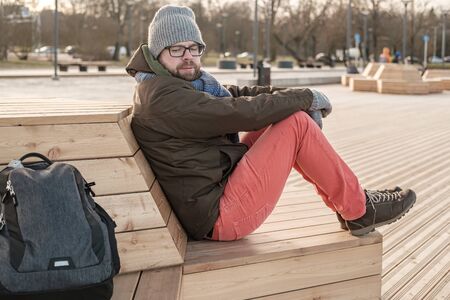 Suspicious tourist looks excitedly at his backpack and is afraid that he will be stolen while...