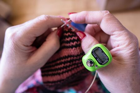 Modern, electronic device for counting loops for hand knitting on knitting needles is worn on the thumb. Top view.の写真素材