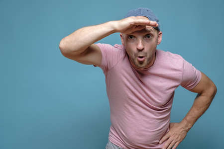 Man is surprised at something, he raised hand to forehead and looks into the distance with a funny expression on face. Copy space.の写真素材