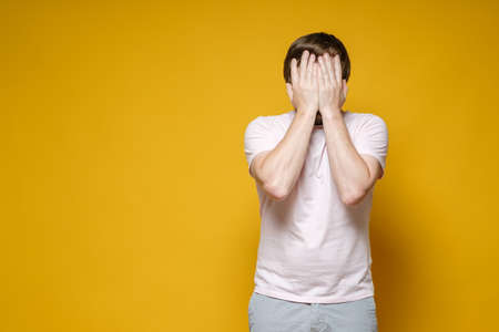 Caucasian man covered his face with his hands. He is upset, stressed and very tired. Copy space....