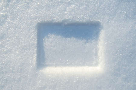 Imprint of a rectangular frame in the snow, on a sunny winter day. Copy space.