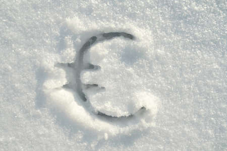 Euro sign written in pure snow on a sunny winter day. Top view.の写真素材